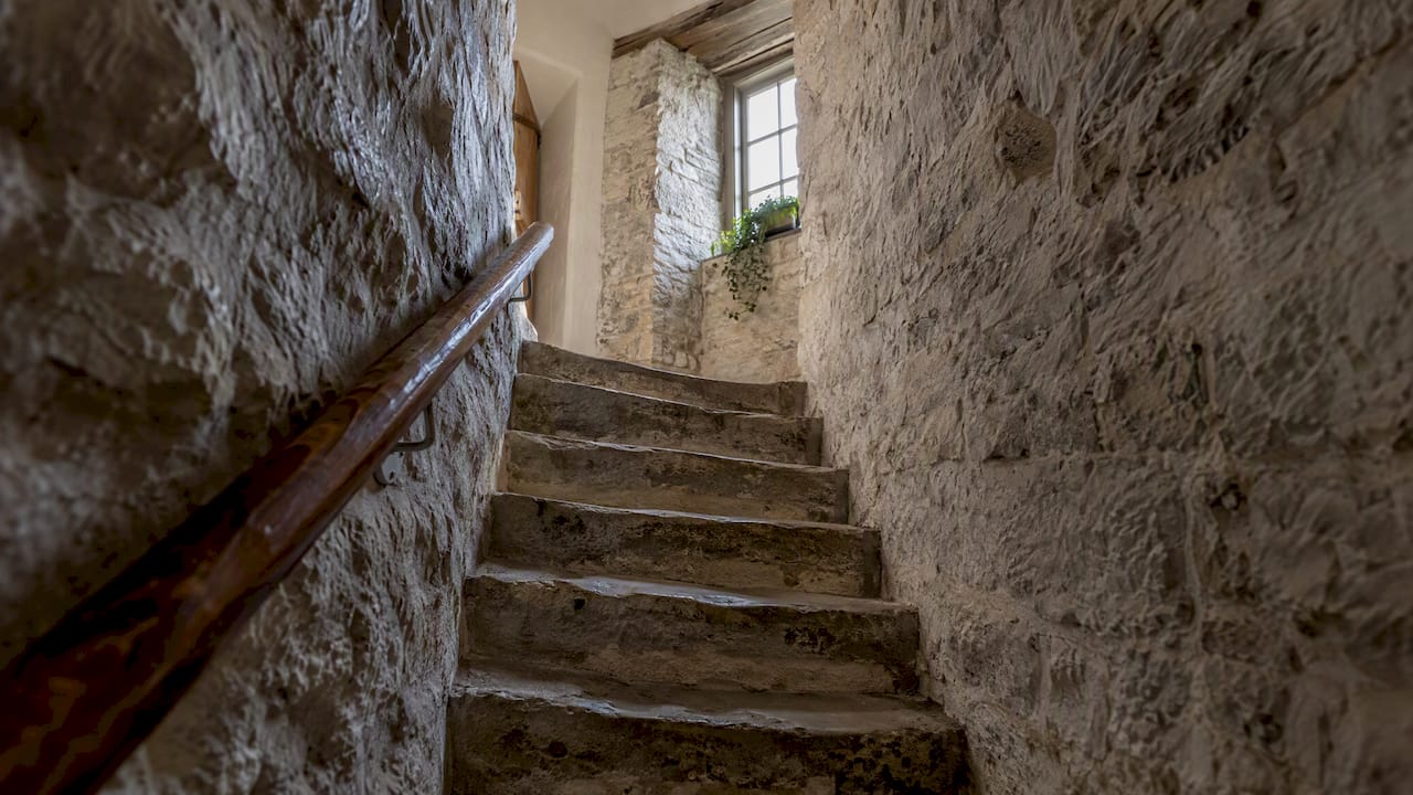 Smal trappa mellan kraftiga stenväggar i ett hus i Visby